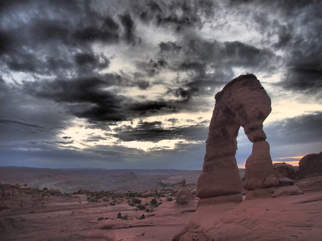 Storm Clouds Hover Over One Of The Natural Stone Formations In Arches National Park, Utah