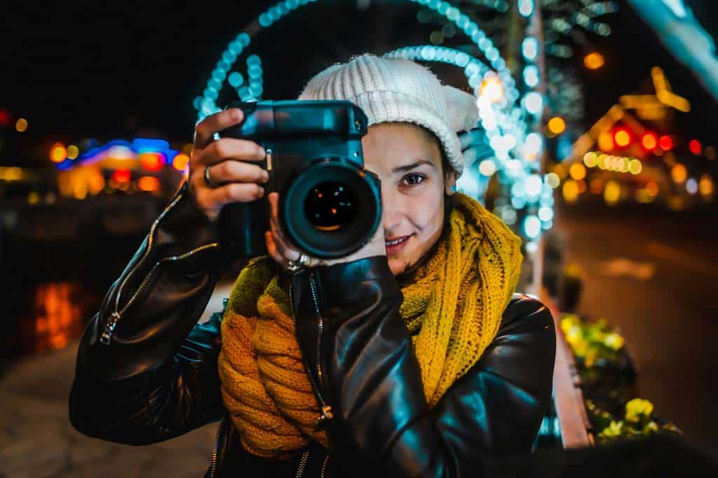 Details Girl Holding Camera With Lights In Background