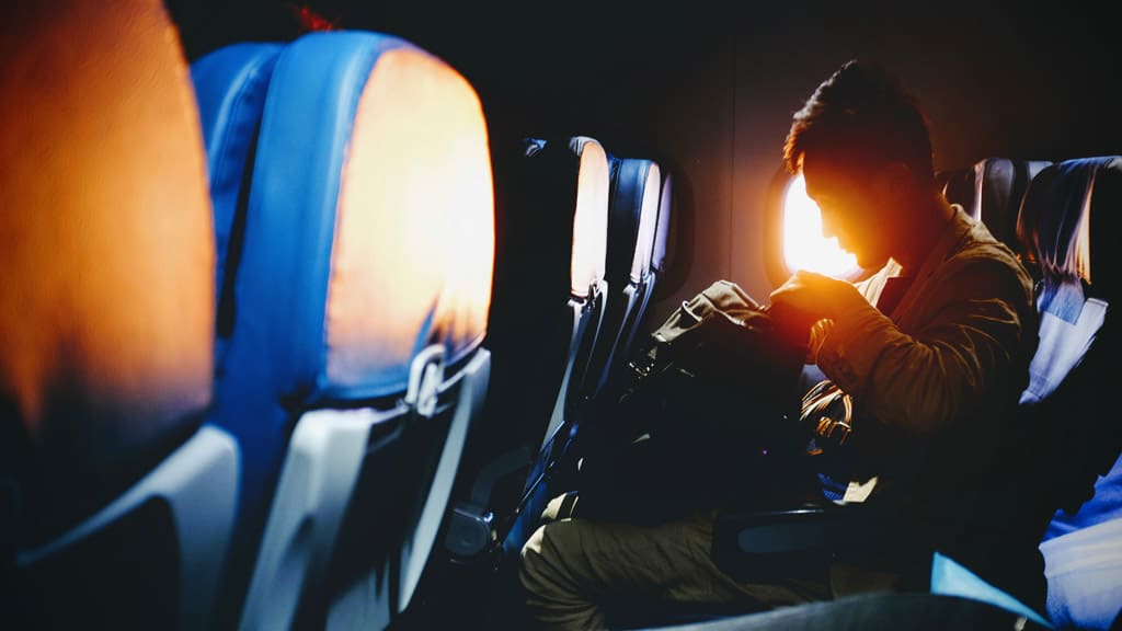 Person On A Plane With Carry On Bag Tips For Carry-On Luggage