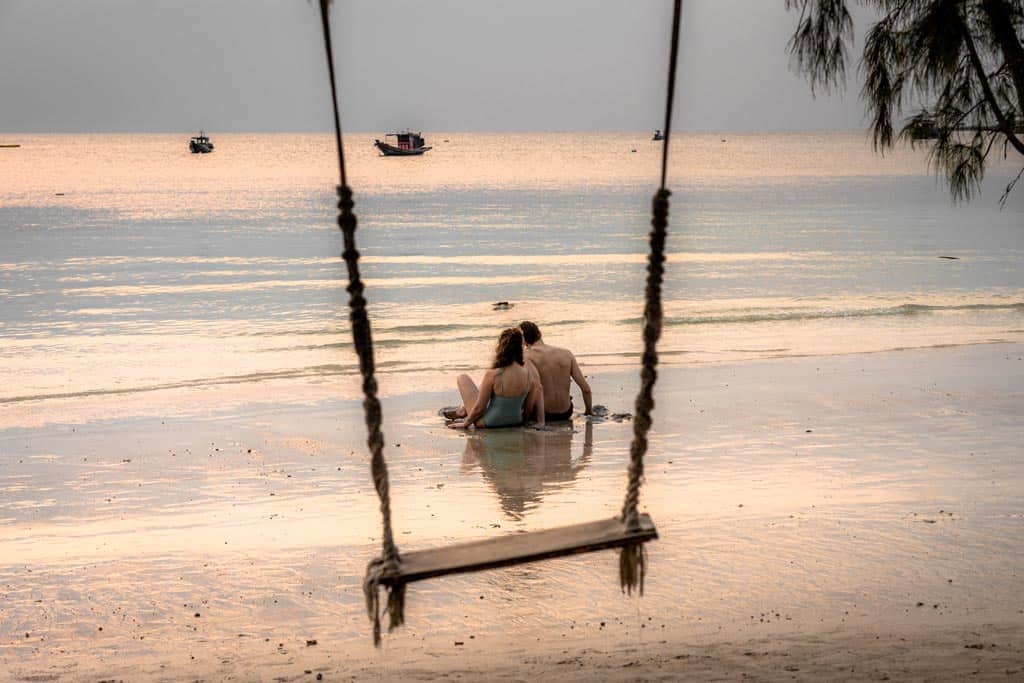 Couple Sitting Between Swing