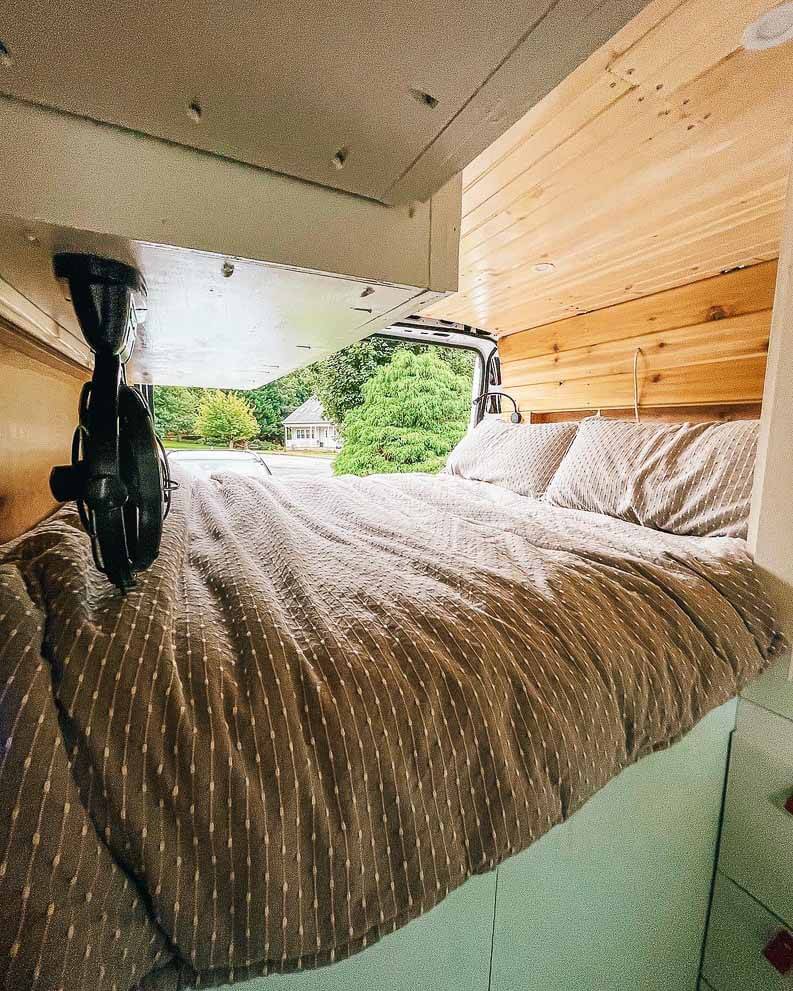 A Fixed Bed With Storage Underneath In A Camper Van