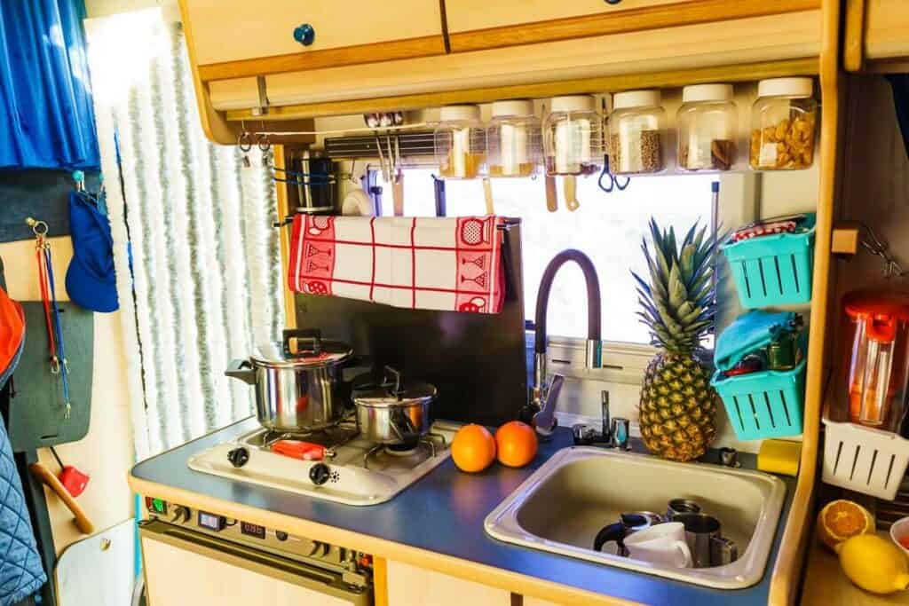 Small Kitchen In A Van Includes A Two Burner Stove And A Separate Small Sink With A Faucet