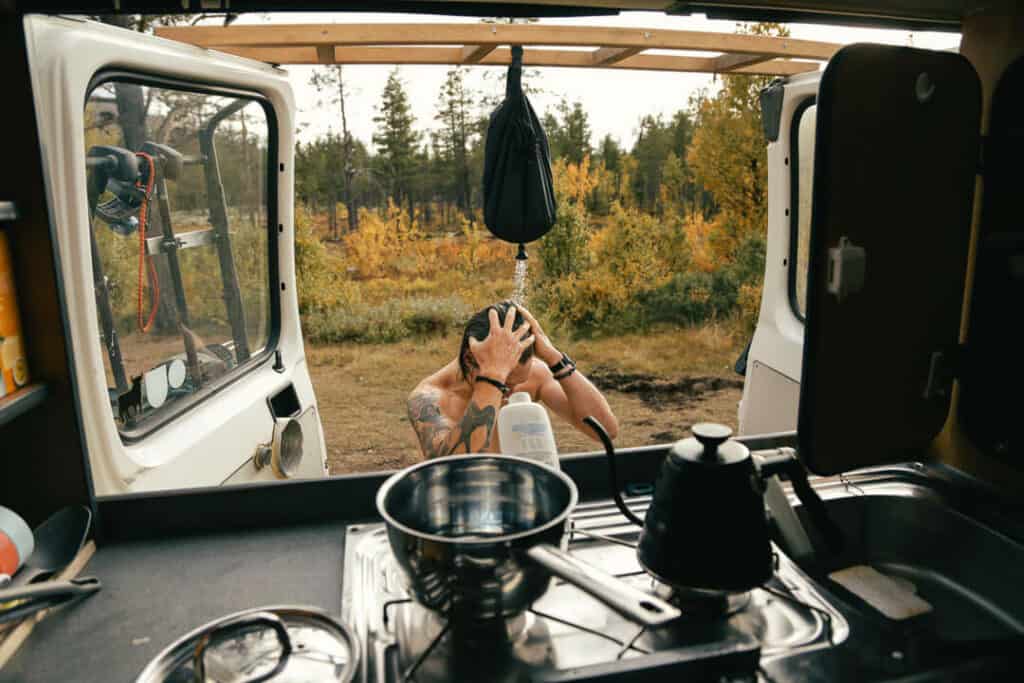 Man Taking Outdoor Shower With Van