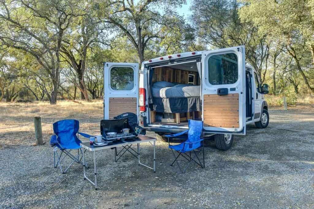 Outdoor Table, Chairs And Camp Stove Setup Outside Of A Van