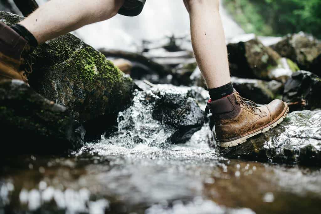 Wandelschoenen over een regenwoudbeek